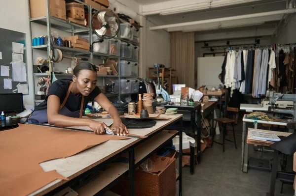 Young African Female Artisan Cutting Leather Using Knife Ruler While — Stock Photo, Image