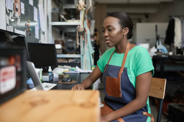 Fiatal Afrikai Női Kézműves Aki Laptopon Dolgozik Miközben Egy Íróasztalnál — Stock Fotó