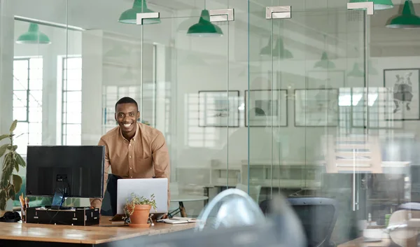 Retrato Jovem Empresário Africano Sorrindo Enquanto Debruça Sobre Sua Mesa — Fotografia de Stock
