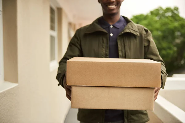 Closeup Smiling African Delivery Man Standing Apartment Walkway Carrying Packages — Stock Photo, Image