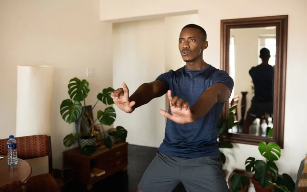 在家中的客厅里 一个人练习太极时 让非洲年轻人穿上运动服呼吸 — 图库照片