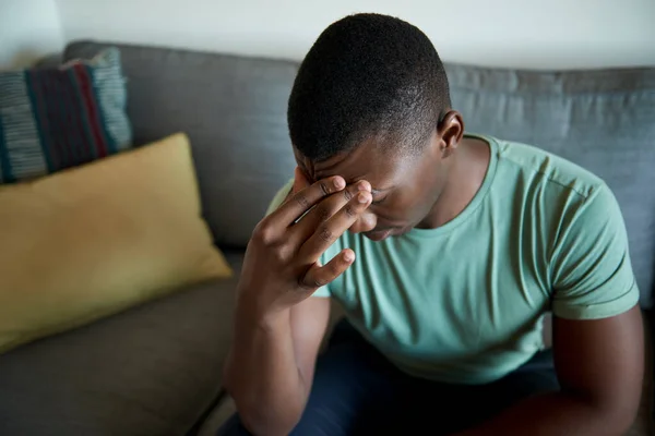 Genç Afrikalı Adam Evdeki Kanepede Tek Başına Otururken Keyifsiz Görünüyor — Stok fotoğraf
