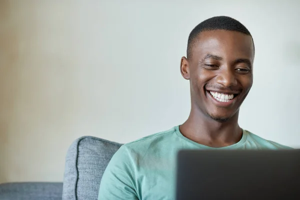 Sorrindo Jovem Africano Sentado Sua Sala Estar Sofá Casa Navegando — Fotografia de Stock