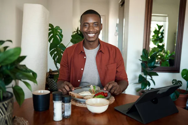 Retrato Joven Africano Sonriente Sentado Mesa Comedor Desayunando Viendo Algo — Foto de Stock