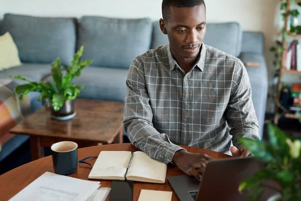 Jovem Empresário Africano Revisando Notas Usando Laptop Enquanto Trabalhava Remotamente — Fotografia de Stock