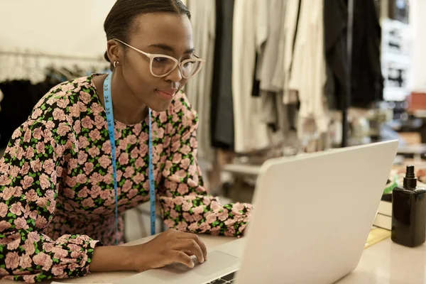 Fokuserad Ung Afrikansk Kvinnlig Modedesigner Arbetar Ensam Bärbar Dator Vid — Stockfoto