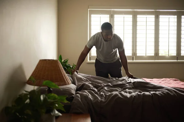 Νεαρός Αφρικανός Στρώνει Κρεβάτι Του Αφού Ξύπνησε Στο Σπίτι Πρωί — Φωτογραφία Αρχείου