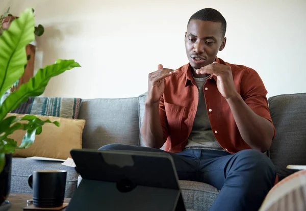 年轻的非洲男子在与同事在数字平板电脑上进行视频通话时 在离家很远的地方与同事交谈 — 图库照片