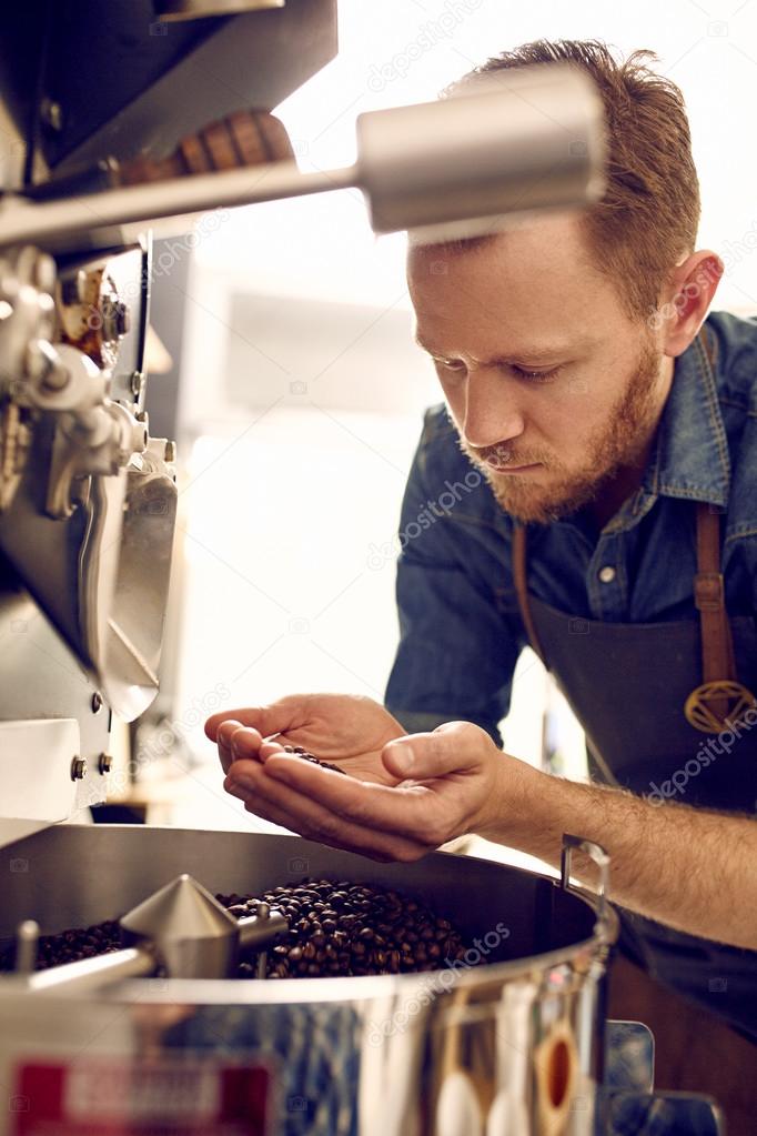 Coffee roaster checking for quality of beans — Stock Photo © mavoimages