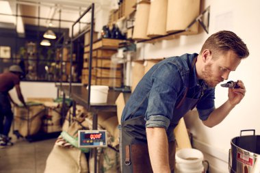 owner smelling roasted coffee beans clipart