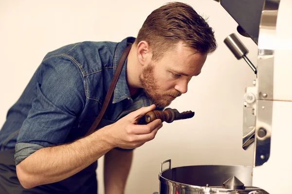 Eigentümer riecht geröstete Kaffeebohnen — Stockfoto