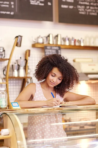 Mujer con en contador de café escribir una orden — Foto de Stock