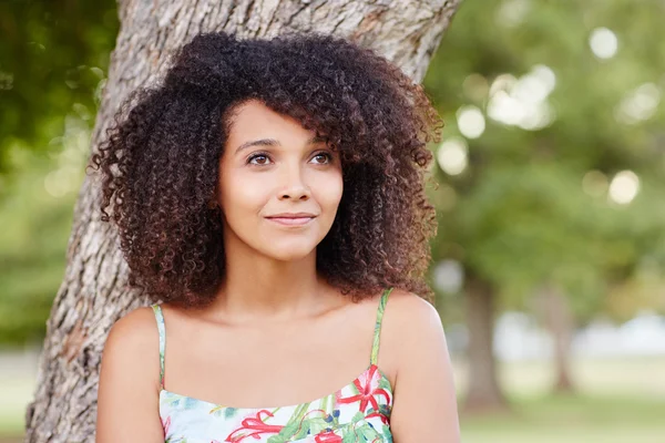 Mujer hermosa sonriendo y soñando despierto en el parque — Foto de Stock