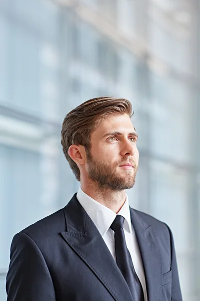 Hombre de negocios mirando hacia arriba pensativo y con confianza —  Fotos de Stock