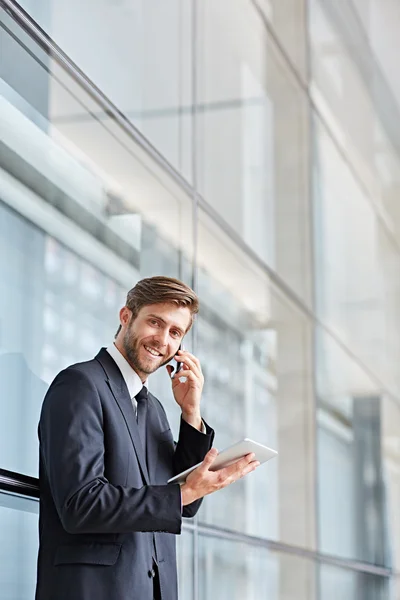 Biznesmen mówiąc na telefon i za pomocą tabletu — Zdjęcie stockowe