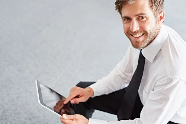 Hombre de negocios usando la tableta en el pasillo de la oficina — Foto de Stock