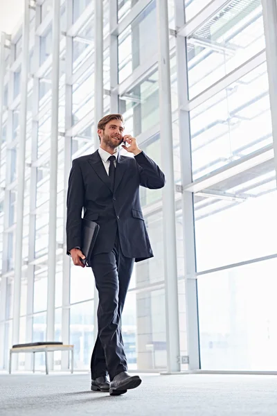 Zakenman praten over telefoon wandelen corridor — Stockfoto