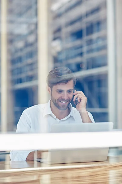 Dizüstü bilgisayarda çalışan ve telefonda konuşurken işadamı — Stok fotoğraf