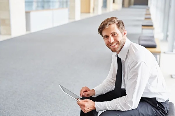 Empresário usando tablet no escritório coridor — Fotografia de Stock