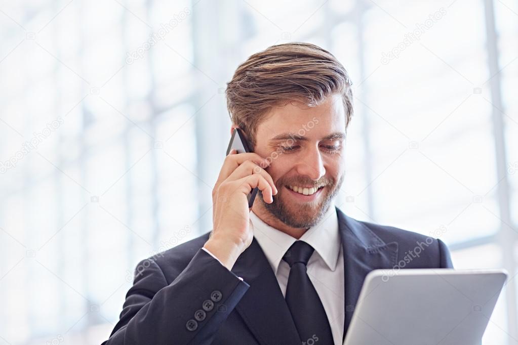 businessman speaking on phone and using tablet