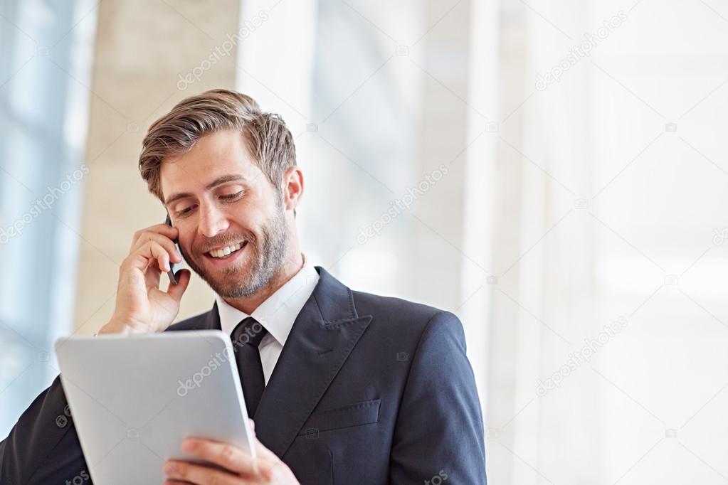 businessman speaking on phone and using tablet