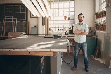designer standing in studio with arms crossed