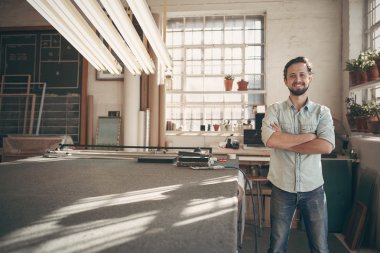 designer standing in studio with arms crossed