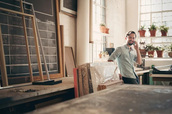 business owner on talking on phone in workshop