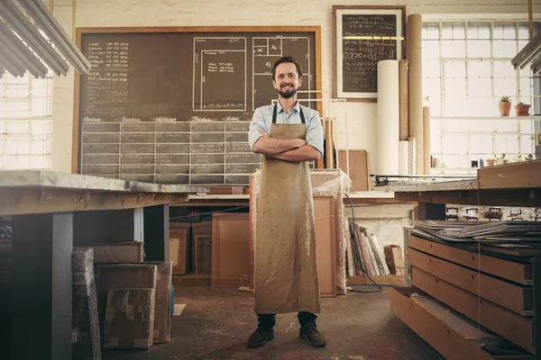 Craftsman in workshop with arms folded — Stok fotoğraf