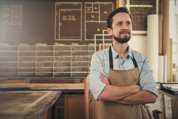 craftsman looking away thoughtfully in workshop