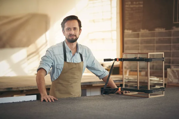 Carpenter standing alongside display case — Stockfoto