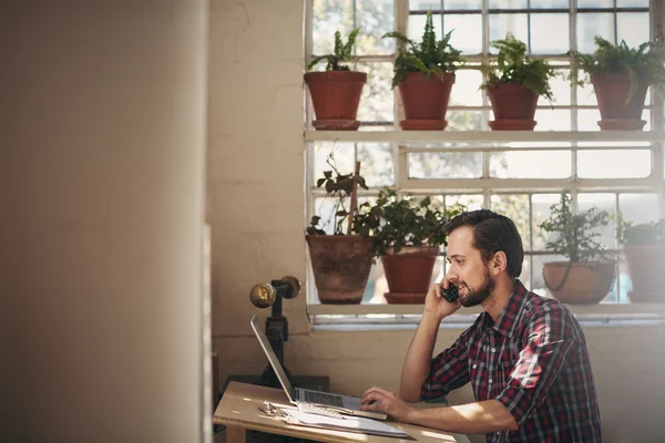 Entrepreneur using phone and working on laptop — Stock Photo, Image