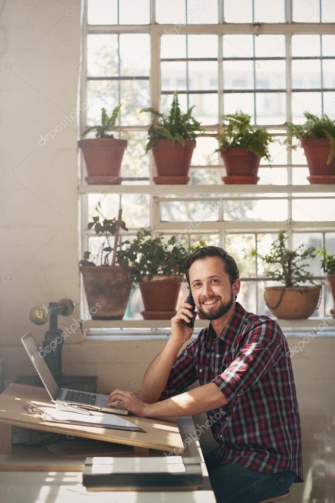 Entrepreneur smiling at camera from studio office