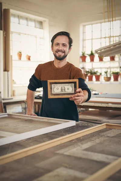 Entrepreneur holding up framed bank note — Stock Photo, Image