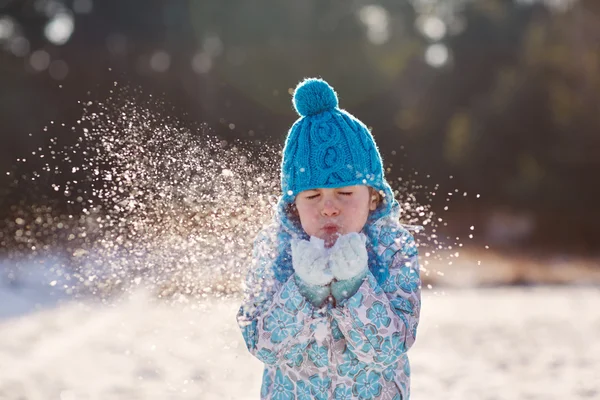 Girl blowing snow flakes from hands Royalty Free Stock Images