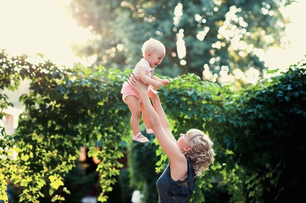 Young mother playing with her little daughter on the nature — Stock Photo, Image