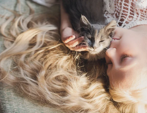 Holčička drží ruce kotě s ohledem na západ slunce, pet, přítel, — Stock fotografie