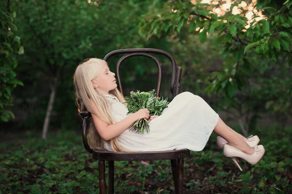 Portrait of a baby girl on vintage chair with a bright bouquet of flowers — Stock Photo, Image