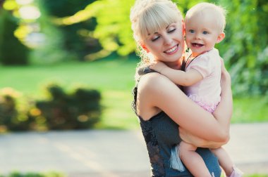 Güzel mutlu anne sarılma bebek kızla aşk açık havada yaz arka plan
