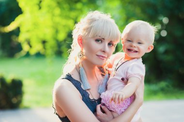 Güzel mutlu anne sarılma bebek kızla aşk açık havada yaz arka plan