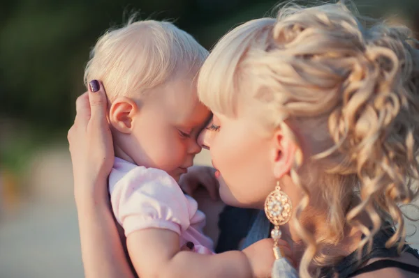 Hermosa madre feliz abrazando a la niña con amor al aire libre fondo de verano —  Fotos de Stock