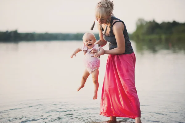 Μαμά παίζει με την μικρή κόρη κοντά στο νερό — Φωτογραφία Αρχείου