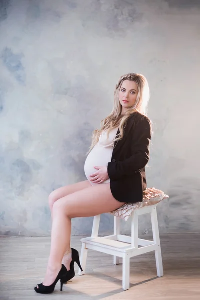 Portrait d'une belle femme enceinte en lingerie blanche et cheveux longs — Photo