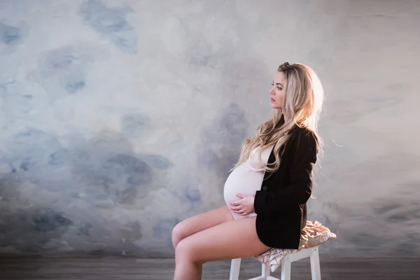 Retrato de una hermosa mujer embarazada en lencería blanca y cabello largo —  Fotos de Stock