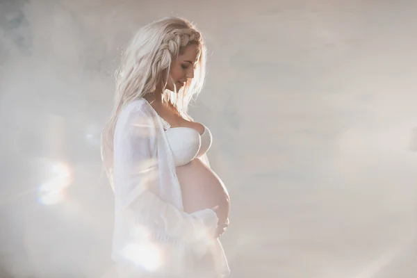 Portréja egy szép terhes nő a fehér fehérnemű és a hosszú haj — Stock Fotó