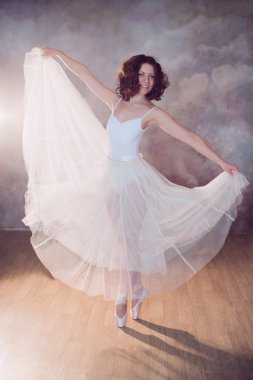 Balerin beyaz mayo ve güzel vücudu ayakta pointe ayakkabıları ile uzun etek