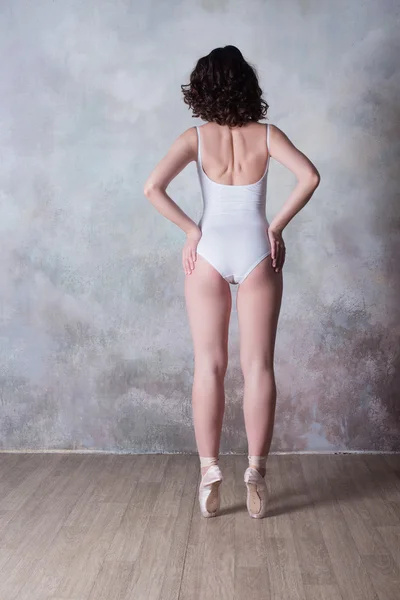 Ballerina in a white bathing suit with a beautiful body standing on pointe shoes — Stock Photo, Image
