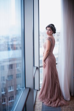 Pencerenin yanında bir güzel elbise pembe ayakta kadında
