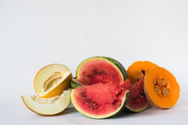 Kavun, karpuz ve beyaz bir arka plan üzerine dilimlenmiş kabak