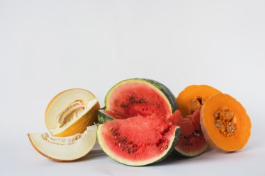 Kavun, karpuz ve beyaz bir arka plan üzerine dilimlenmiş kabak